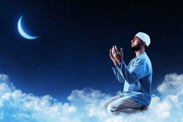 Young asian muslim man with beard praying at night sky with stars and moon