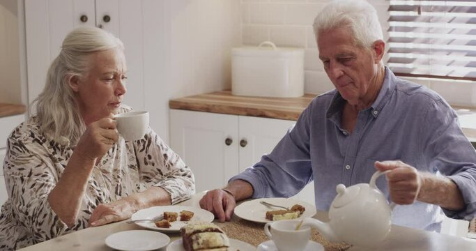 Tea cup, kitchen and senior couple drink liquid in morning brunch together with love, care and romance. Retirement, home and relax elderly man, senior woman or people with hot beverage, matcha or mug