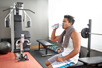 Fitness, gym and man drinking water for training, wellness or exercise recovery, break or resting....