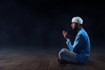 Young asian muslim man with beard praying on dark background - 739690115