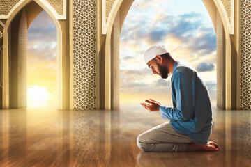 Young asian muslim man with beard praying in the mosque door arch at beautiful sunset sky - 739690362