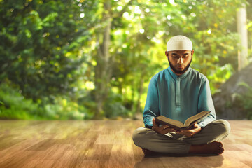 Young asian muslim man with beard reading holy book quran at home - 739690508