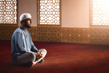 Portrait of young asian muslim man with beard  sitting in empty mosque at sunset - 739690799