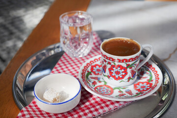 a cup of turkish coffee served with water and turkish delight on table 