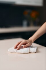 Woman's Hand Wiping White Kitchen Table, Removing Dirt and Wet Dough with Cloth, Creating Fresh Homemade Bread
