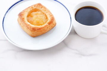 美味しそうなリンゴのデニッシュとコーヒーでおやつの時間
