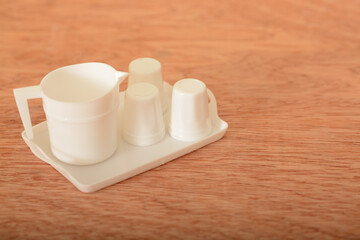 Tea cup toy set on a wooden table. Kids tea coffee serving set