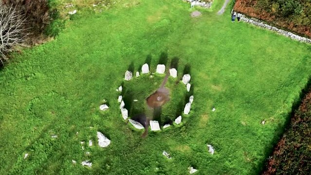 Top down aerial drone shot rising up over the Drombeg Stone Circle, an ancient historical landmark in County Cork, Ireland 