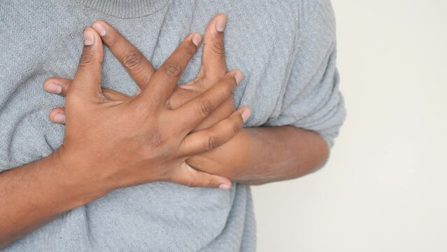 young man suffering pain in heart and holding chest with hand 