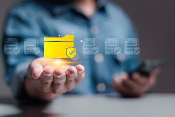 Corporate data management system concept. Personal data and corporate personal data protection. Person hold folder icon with shield protection on virtual screen for document secure confidential access
