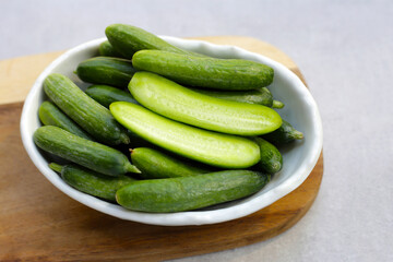 Mini cucumbers on grey background.