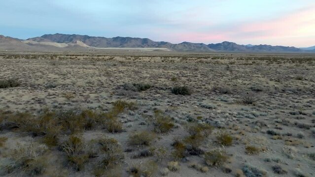 Arizona desert landscape with mountains in the distance and drone video moving low and forward.