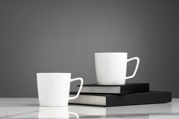 Fototapeta na wymiar Ceramic cups on marble table against gray background