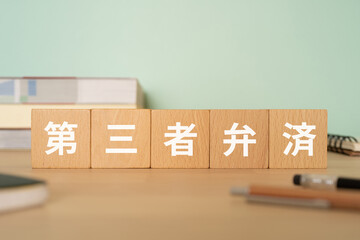 第三者弁済の文字が入ったブロックが置かれたデスク
