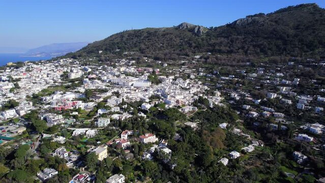 Hilltop white houses of Anacapri Italian island. Aerial dolly in