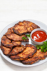 fried juicy pork steaks with ketchup on plate