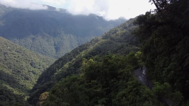 Aerial follows cyclists descending famous Yungas Death Road, Bolivia
