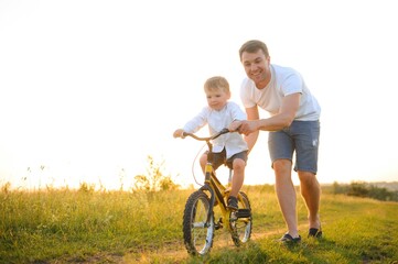 Father teaching his son how to ride a bicycle