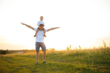 father's day. Dad and son playing together outdoors on a summer. Happy family, father, son at sunset.