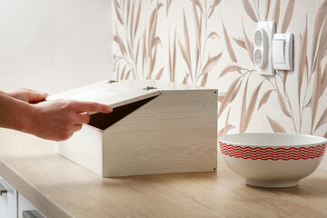 Woman opening wooden bread box on the kitchen counter	 - obrazy, fototapety, plakaty