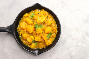 Pumpkin curry is a rich and aromatic dish made with tender pumpkin chunks cooked in a blend of spices like cumin, coriander, and turmeric along with onions and tomatoes. Kaddu masala. copy space