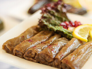 MALFOOF or Stuffed Cabbage leaves rolls with lime and salad served in dish isolated on wooden table top view of cold mazza arabic food