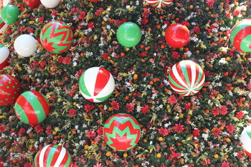 Large colorful decorations on a large Christmas tree. 