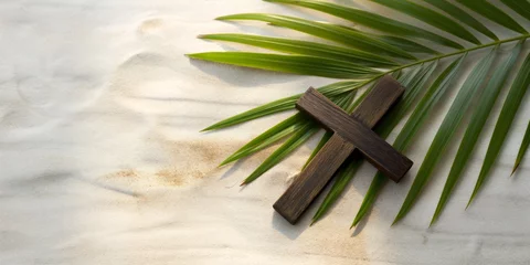 Fototapeten A palm branch and a wooden Christian cross lie on the sand. View from above. Palm Sunday. © Honey Bear