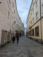 Crowd strolling on an old city sidewalk in the historic district: Linz, Austria