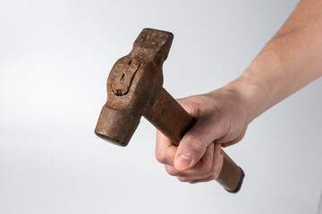 A close-up of an iron hammer in a worker's hand