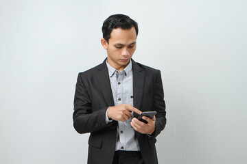 happy asian indonesian business man in suit holding smart phone on isolated background