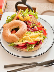 Bagel scrambled eggs with mixed salads for breakfast. Morning time. Fresh meal. Delicious food....