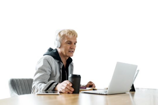 An older dude is using a laptop to browse the web with his earphones. A clear background.