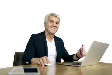 An elderly gentleman uses a laptop while working in an office setting. The background is clear.