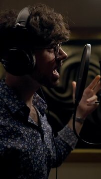 Talented singer guy singing new song in audio record studio