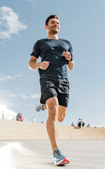 Energetic man jogging in urban surroundings, showcasing health and active lifestyle.