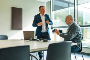 Businessman presenting a new virtual reality goggles to a client