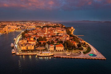 Zadar, Croatia - Aerial panoramic view of golden glowing old town of Zadar with the greeting to the...