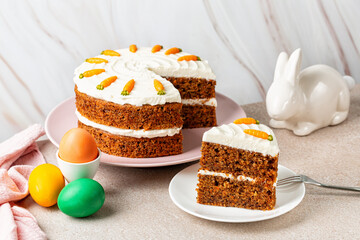 Easter dinner. Slice of Carrot cake, colorful eggs and bunny. Holiday homemade food, light background.
