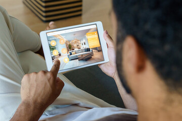 Man adjusting household functions, lighting, security cameras, door locks and thermostat or heating settings in smart home system.