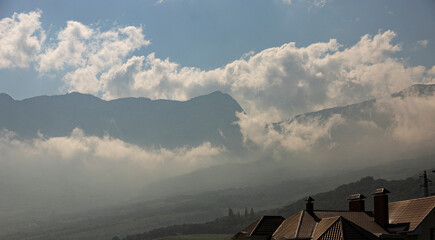 Mountain scenery, clouds on top of a mountain range descend smoothly downwards.