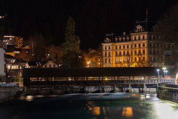 night view of the town, sluice bridge over the river wiht a big old building in the background