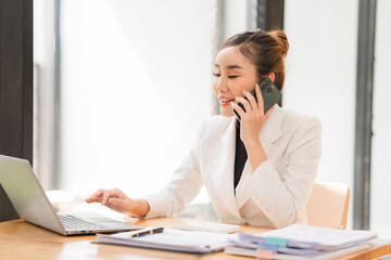 Asian businesswoman use laptop computer in office The Internal Revenue Service audit document balance calculation report is being prepared.