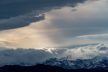 光差す雲と雪山
