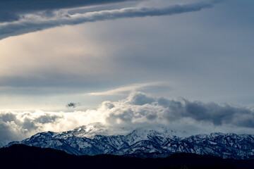 光に照らされる雲と雪山