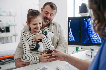 Doctor explaining test results to father of young girl patient. Concept of children healthcare and...