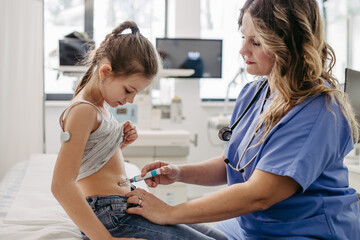 Nurse injecting insulin in diabetic girl belly. Close up of young girl with type 1 diabetes taking...