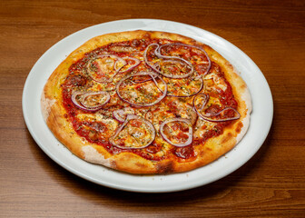 Italian pizza with bacon and onions on a plate.