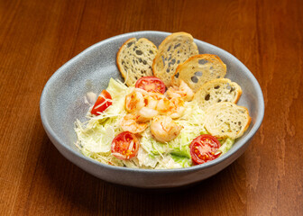 Caesar salad with shrimp in a plate.