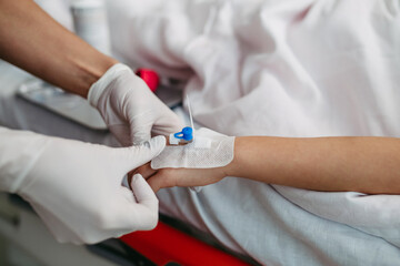 Close up of nurse insering IV cannula in little girl hand. IV, intravenous therapy for child...
